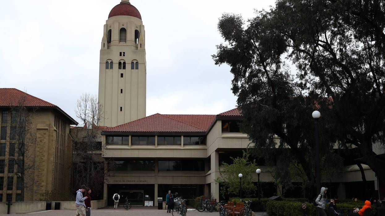 People walk by Hoover Tower on the Stanford University campus on March 12, 2019 in Stanford, California.