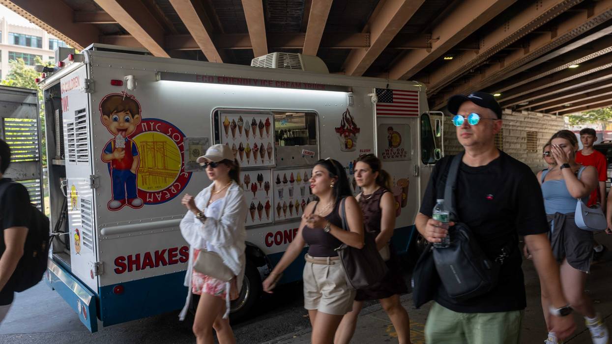 People walk near the Brooklyn Bridge on day when the heat index is expected to top 100 degrees