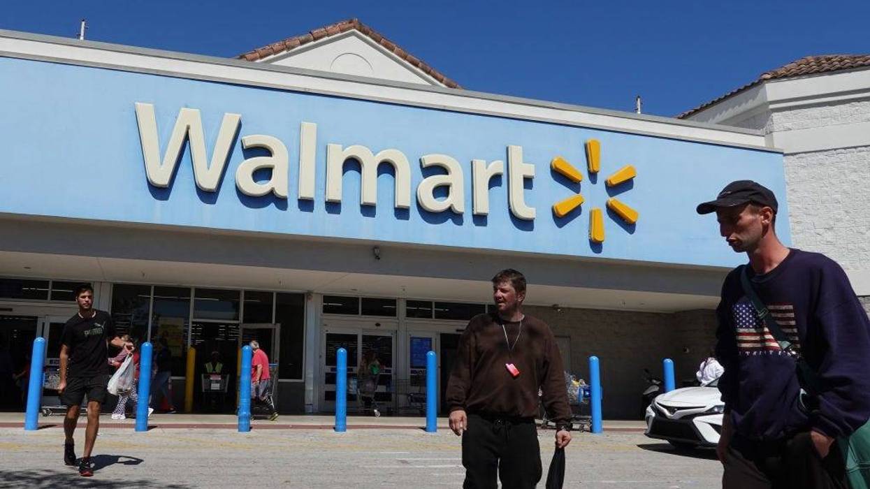 : People walk near the entrance to a Walmart Supercenter