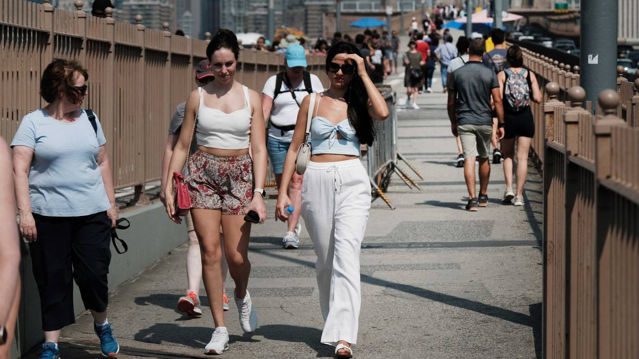 People walk on the Brooklyn Bridge during the heat wave on July 27, 2023