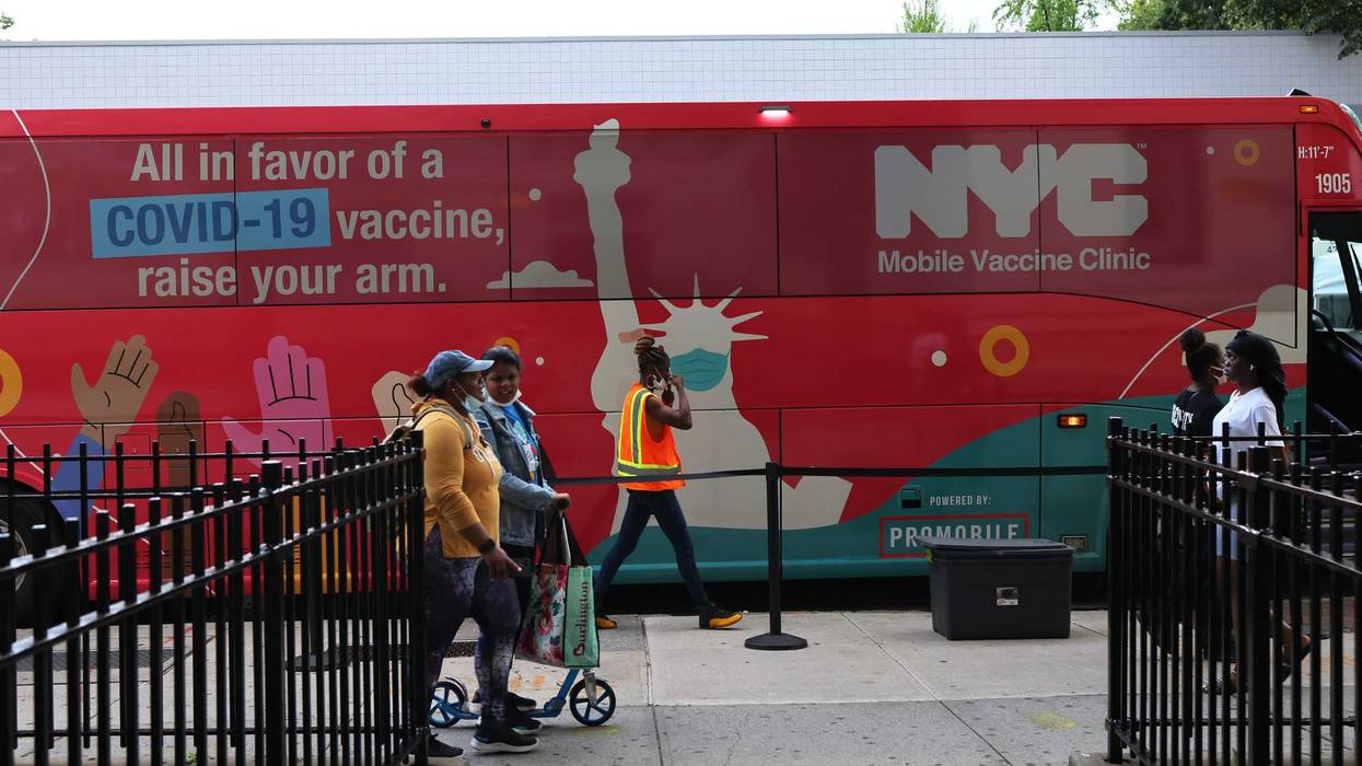 People walk past a mobile vaccination site on Flatbush Avenue on June 09, 2021 in the Flatbush neighborhood of the Brooklyn borough on New York City