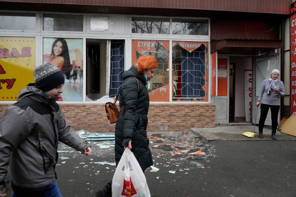 People walk past the aftermath of Russian shelling in Kyiv, Ukraine, Thursday, Feb. 24, 2022