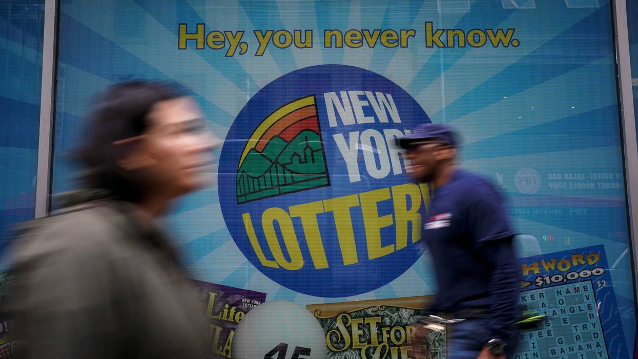 People walk past the New York Lottery Customer Service Center in Lower Manhattan.