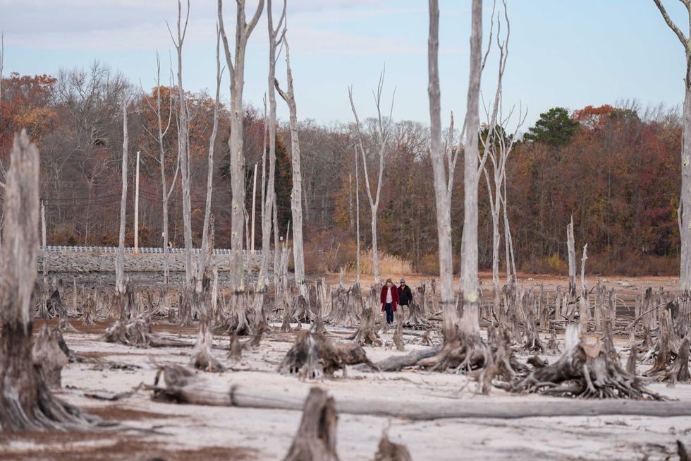 People walk this week in the bone-dry Manasquan Reservoir, which supplies water to 1.2 million people in New Jersey
