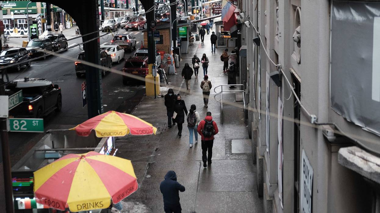 People walk through a neighborhood among those that have seen some of the highest number of city Covid-19 deaths on February 23, 2021 in the Queens borough of New York City.