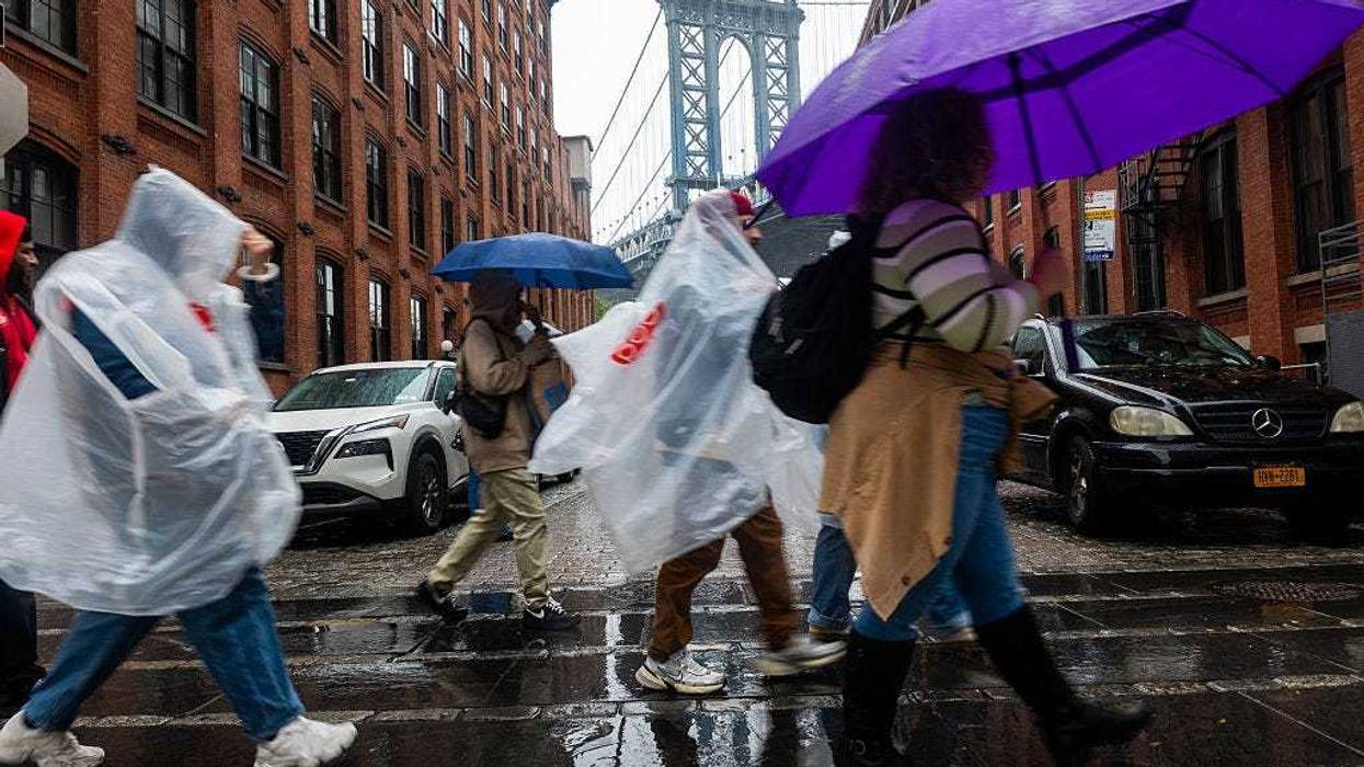 People walk through Brooklyn in the rain as New York City experiences wind and rain associated with a nor’easter storm moving through the region on October 13, 2025.