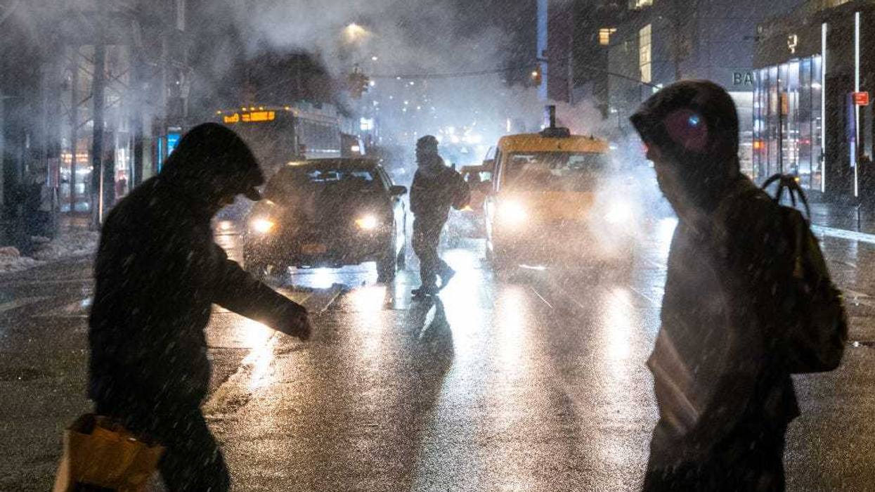 People walk through Manhattan during evening snow on Feb. 11, 2025 in New York City.