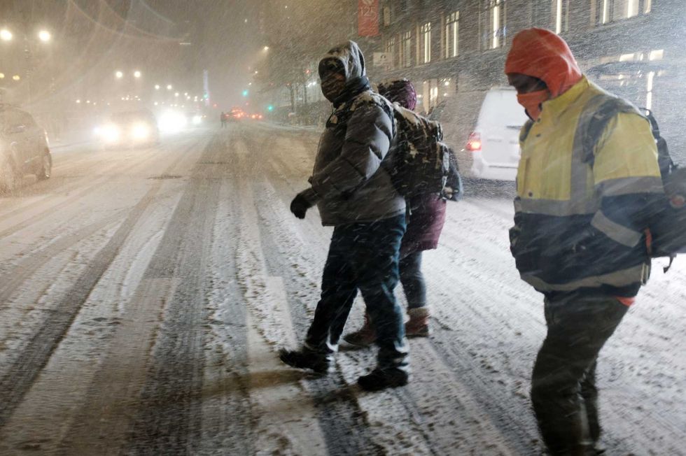 People walk through Manhattan in a snow storm on December 16, 2020 in New York City.