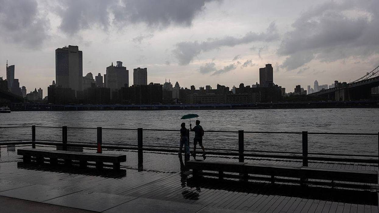 People walk through the rain in the Dumbo neighborhood in Brooklyn as severe storms move through the New York area on July 21, 2026.