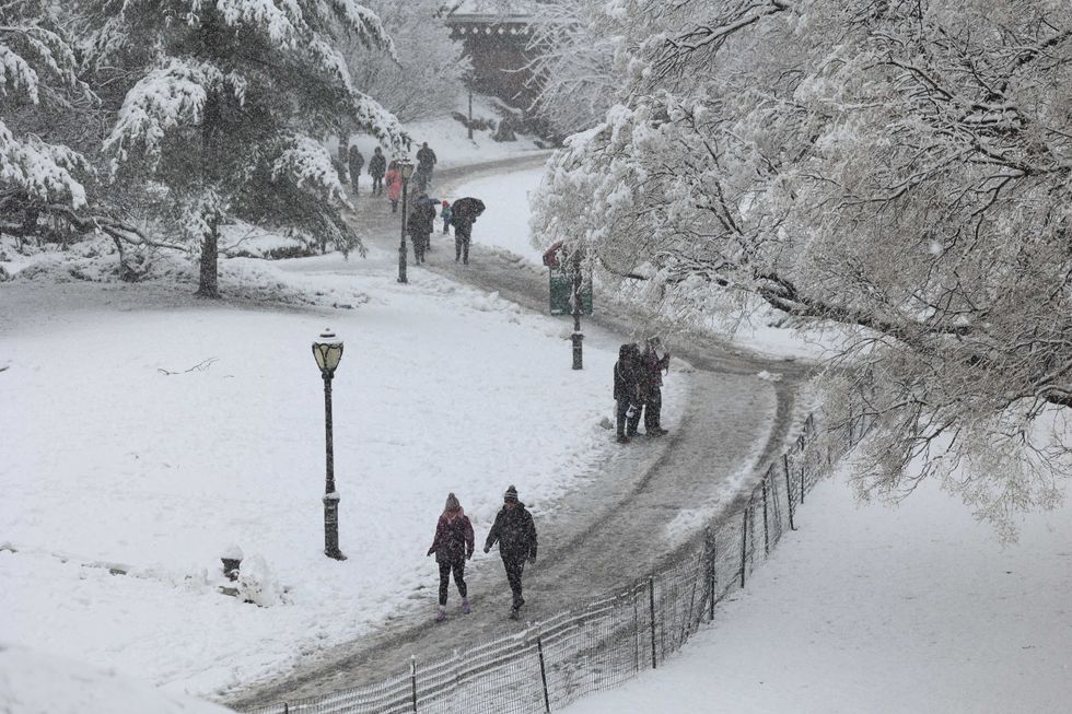People walk through the snow in Central Park on February 13, 2024