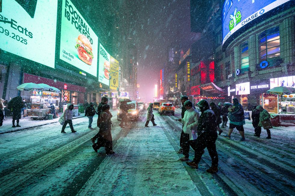 People walk through Times Square during a snow storm on Feb. 8, 2025