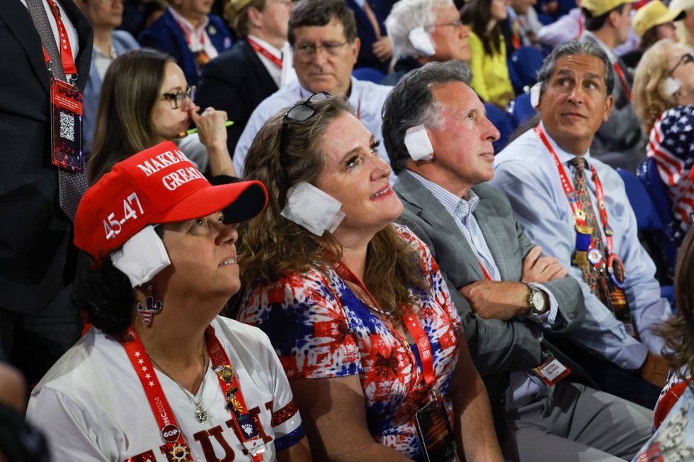 People wear "bandages" on their ears as they watch on the third day of the Republican National Convention at the Fiserv Forum on July 17, 2024, in Milwaukee, Wisconsin.
