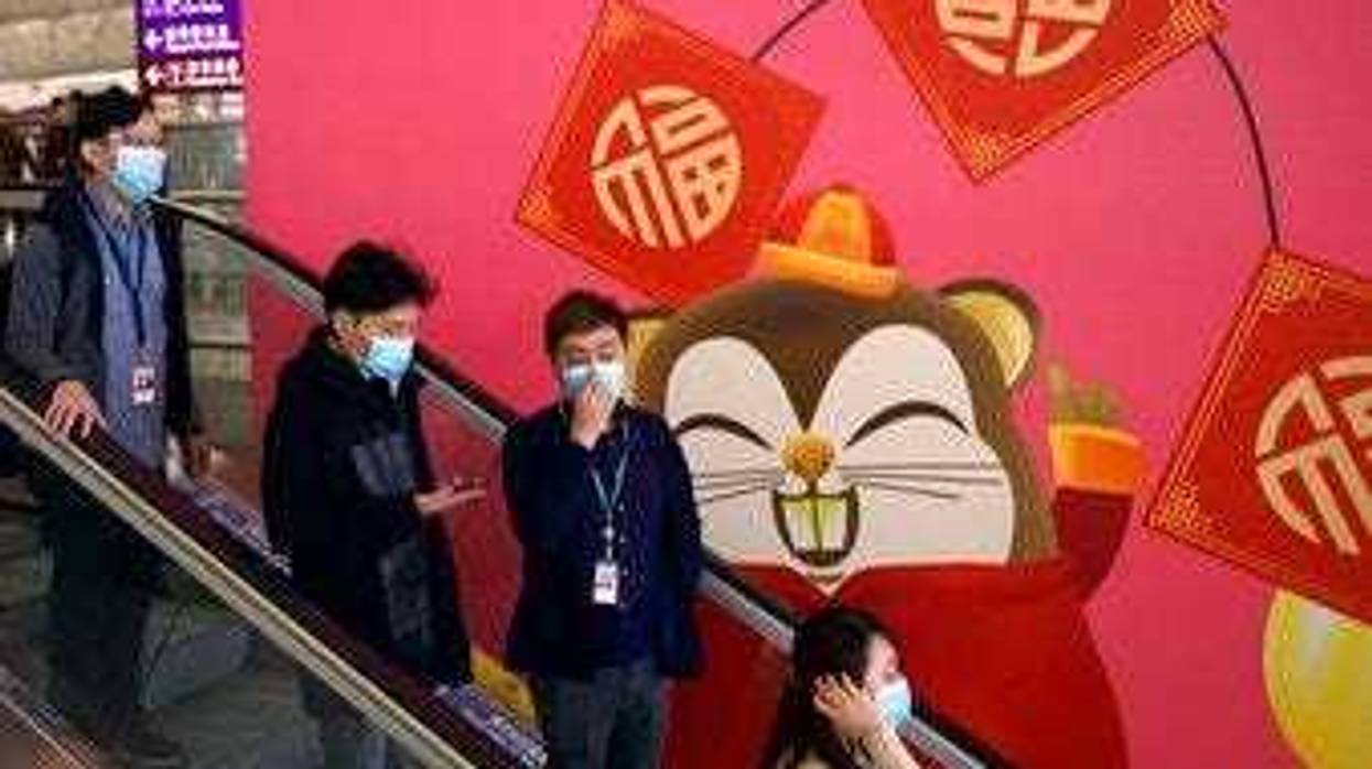 People wear face masks as they ride an escalator at the Hong Kong International Airport in Hong Kong, Tuesday, Jan. 21, 2020.(AP Photo/Ng Han Guan)