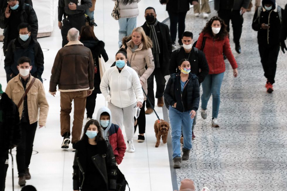 People wear masks at an indoor mall in The Oculus in lower Manhattan on the day that a mask mandate went into effect in New York on December 13, 2021 in New York City