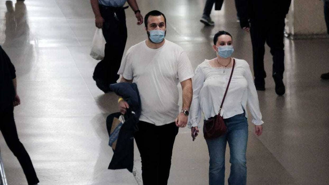 People wear masks inside a store on May 17, 2022 in New York City. New York’s health commissioner, Dr. Ashwin Vasan, has moved from a "medium" COVID-19 alert level to a "high" alert level in all the five boroughs following a surge in cases. (Photo by Spencer Platt/Getty Images)