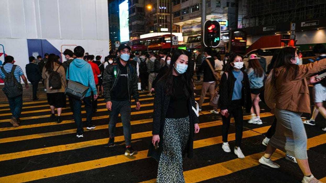 People wear protective masks and cross the street in Hong Kong December 9, 2020 in Hong Kong, China.