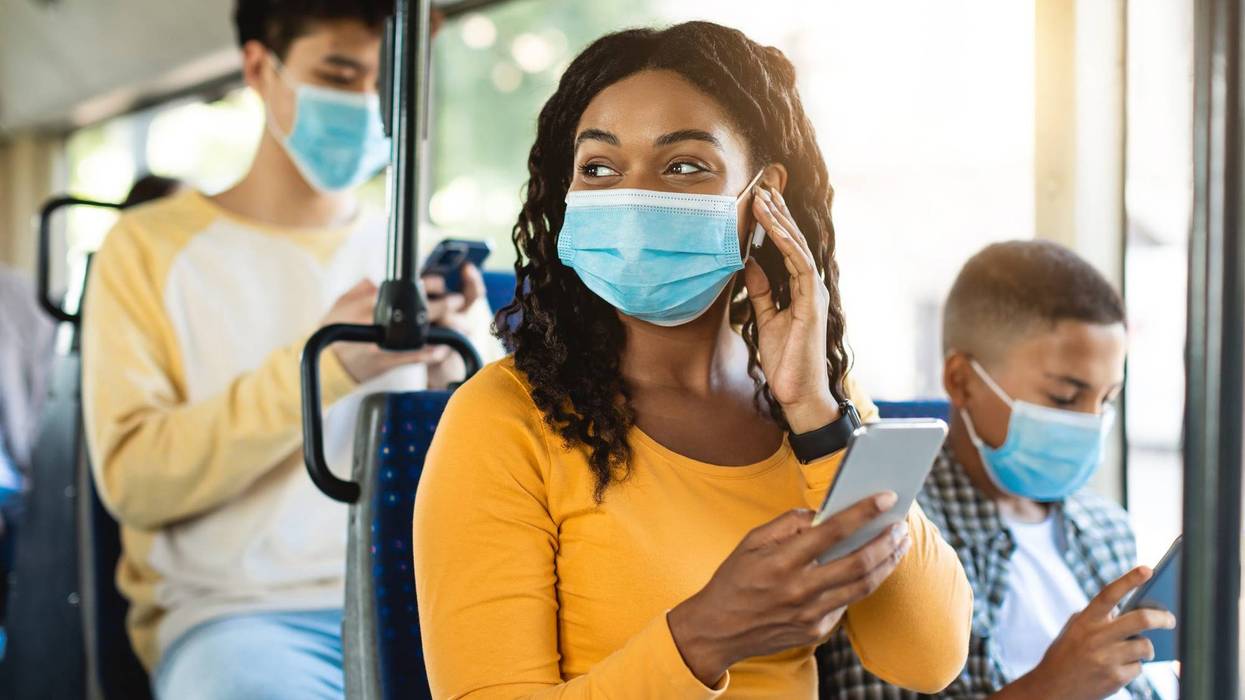People wearing face masks while traveling on public transit.