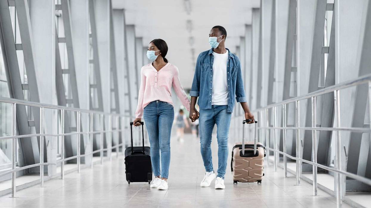 People wearing masks in an airport stock photo.