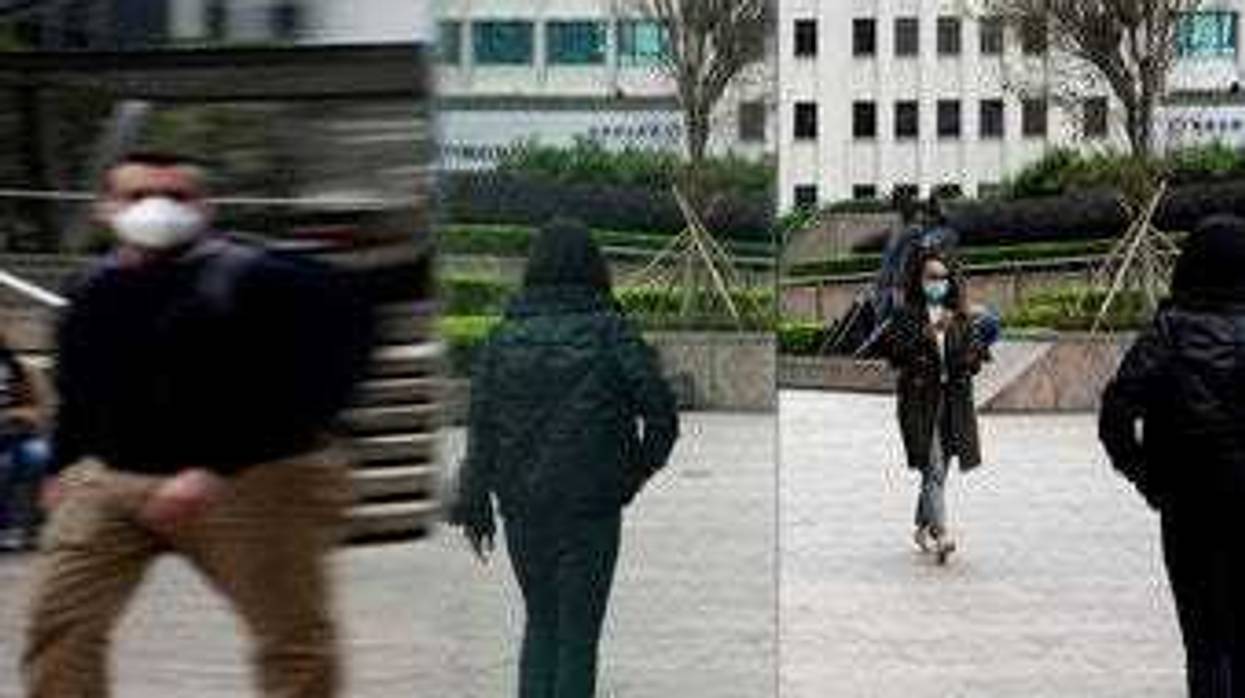 People wearing protective face masks, walk on a street in the Central, the business district of Hong Kong, Tuesday, Feb. 11, 2020. (AP Photo/Kin Cheung)