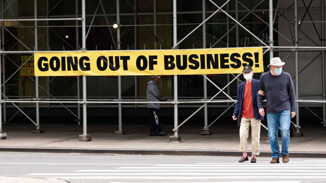 People wearing protective masks walk by a going out of business sign displayed outside Century 21 on the Upper West Side, Sept. 27, 2020, in New York City.