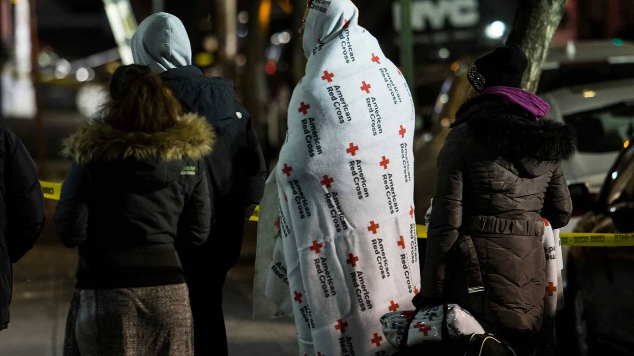 People who evacuate from their house after a fatal major house fire on Prospect avenue on December 29, 2017 in the Bronx borough of New York City. Over 170 firefighters respond to the evening fire in which at least 12 persons were killed with others injured.