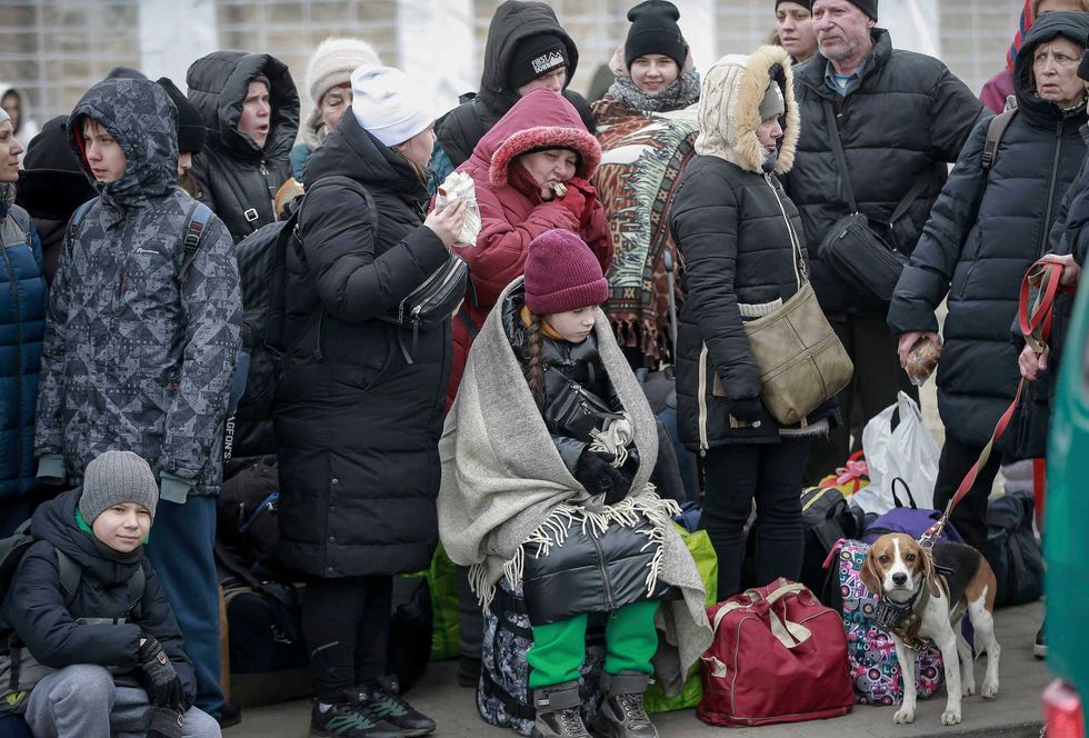 People who left Ukraine, wait for a bus to take them to the train station in Przemysl, at the border crossing in Medyka, Poland, Friday, March 4, 2022