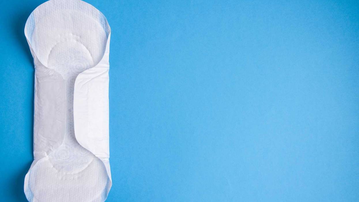 Period pad on blue background stock photo.