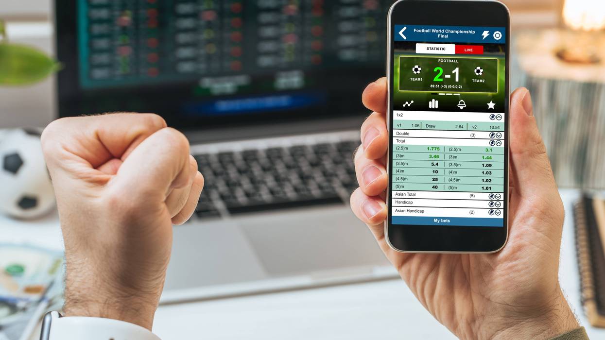 person checking sports betting website on phone