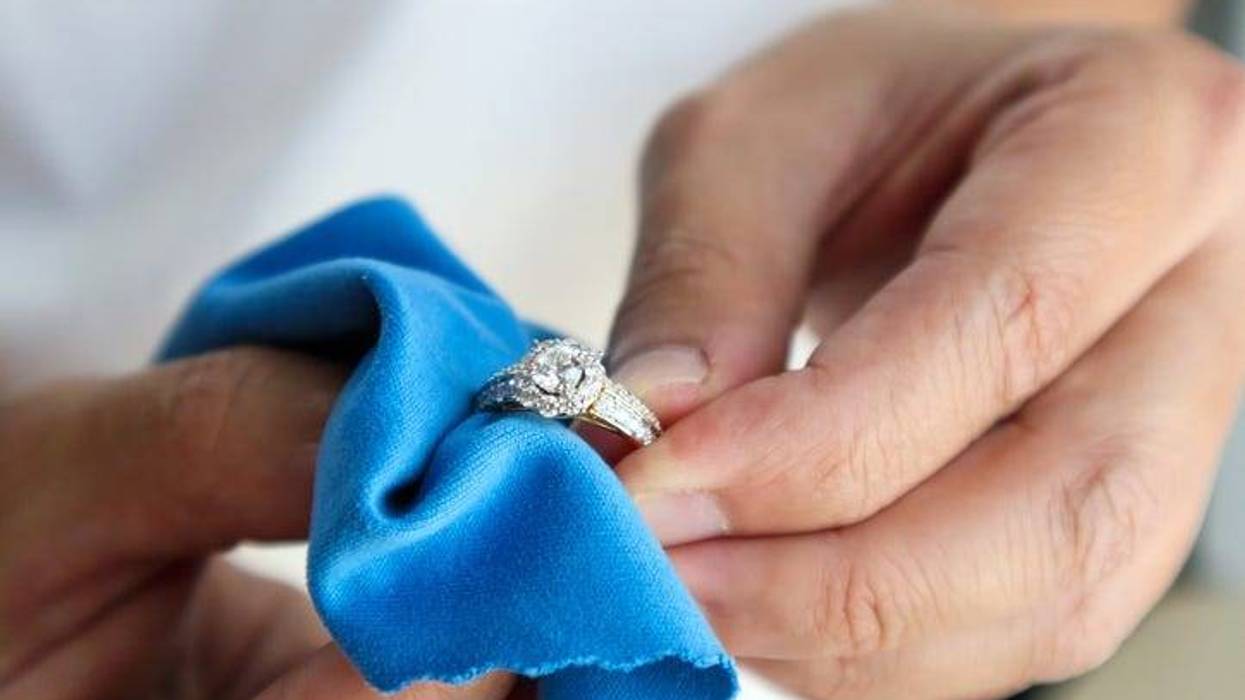 person cleaning a ring with a soft towel