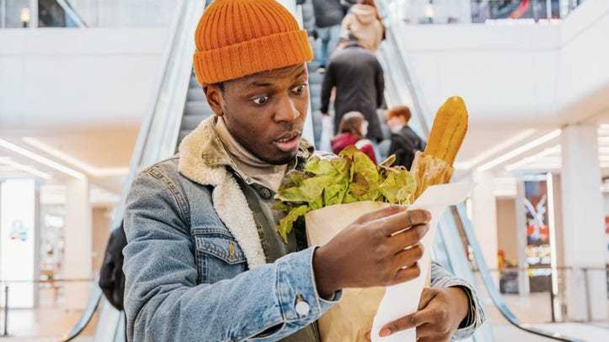 Person examining their receipt realizing how much they spent.