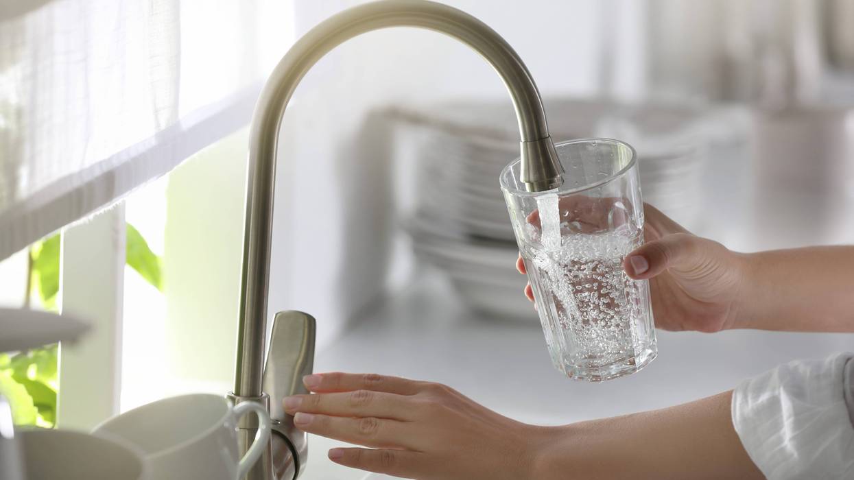 Person filling a glass of water