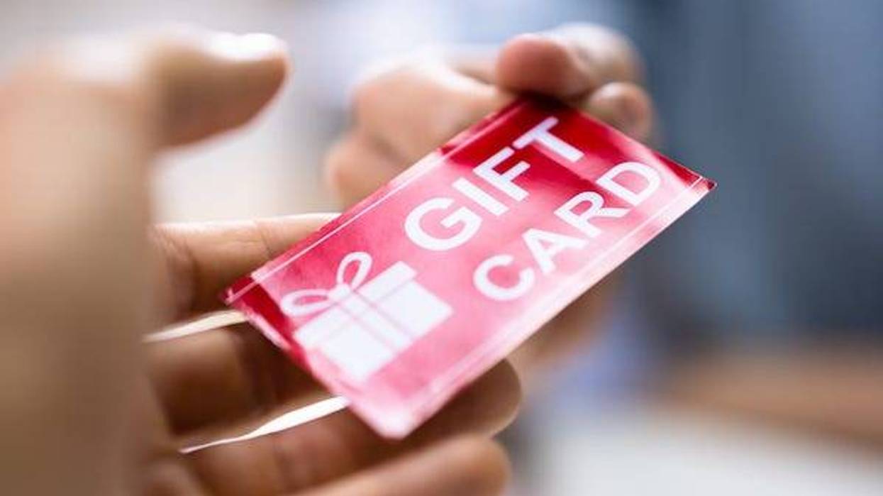Person handing a gift card to a cashier