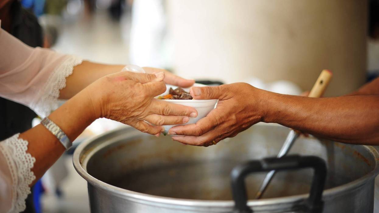 person hands another person a bowl of soup