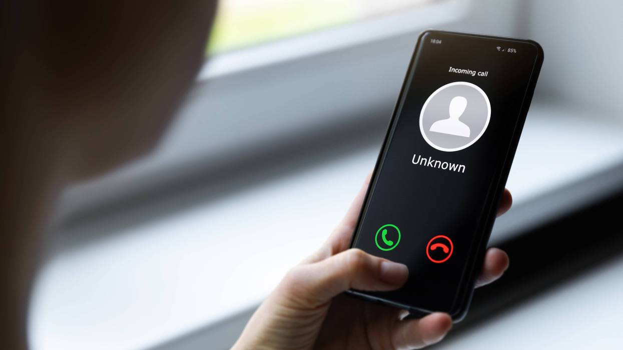 person holding phone receiving a call from an unknown number