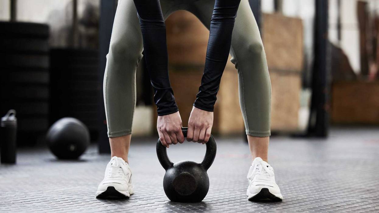 Person lifting a kettle bell to workout.