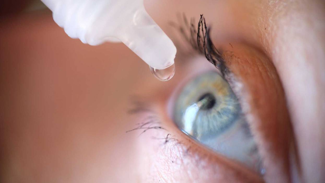 Person putting in eye drops.