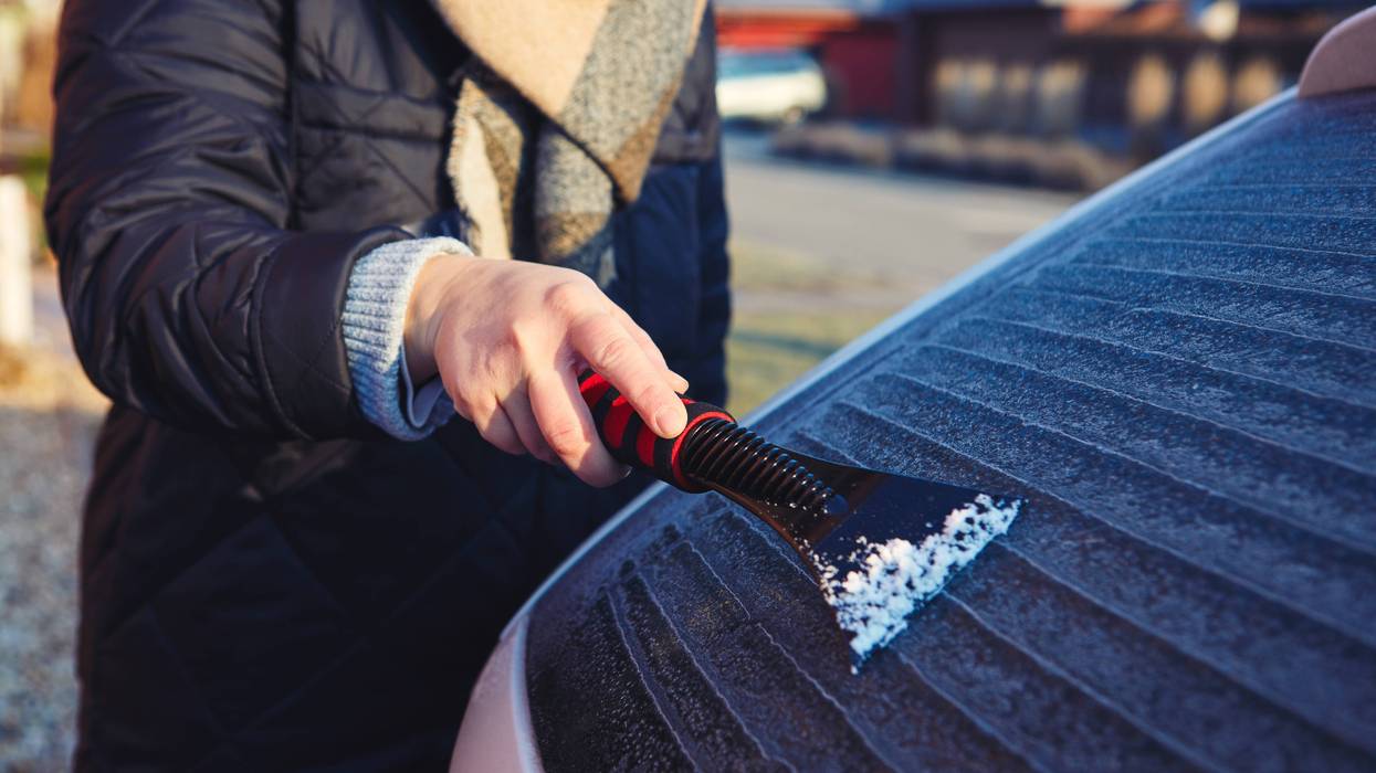 Person scraping ice off car window