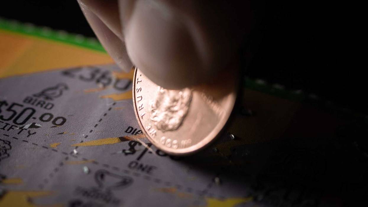 Person scratching off a lottery ticket.