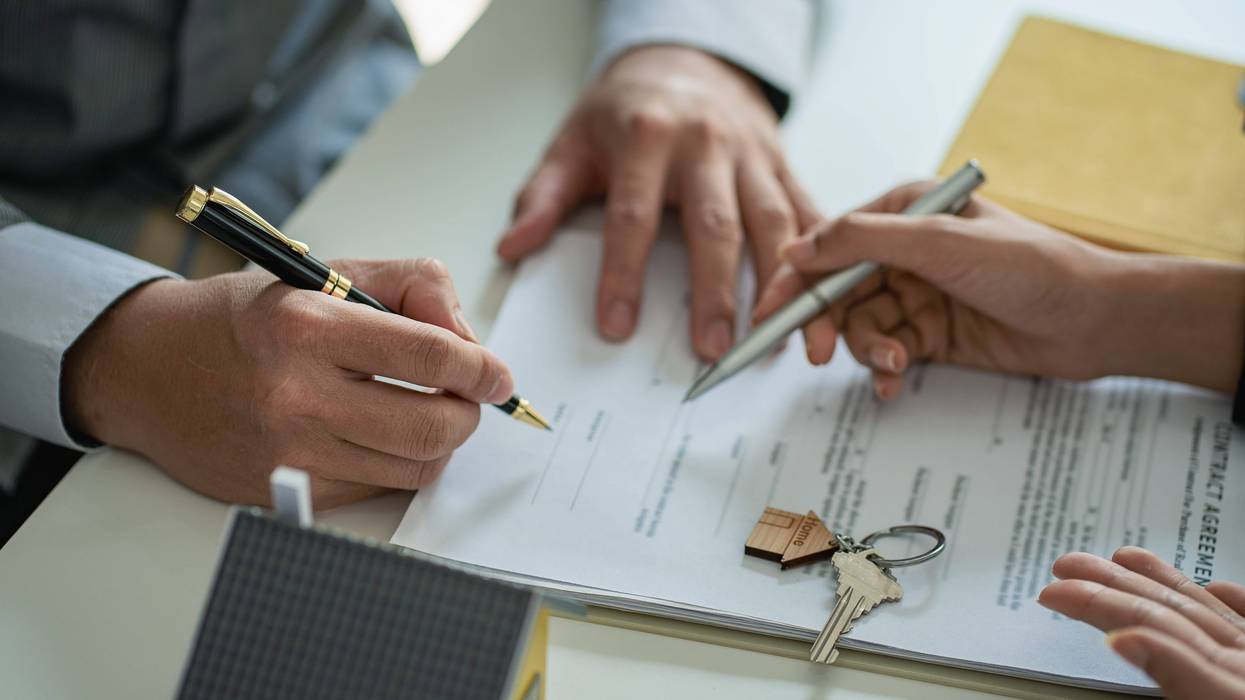 Person signing papers in purchasing a house