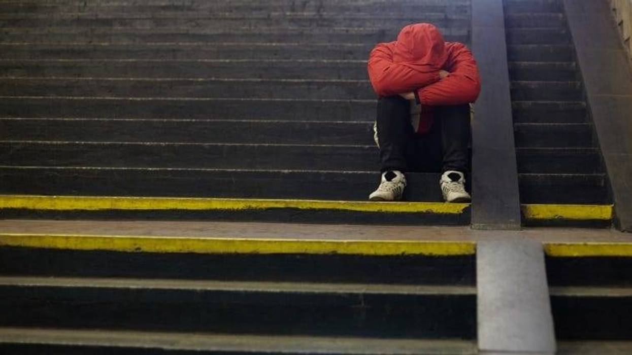 person sitting on stairs with head down