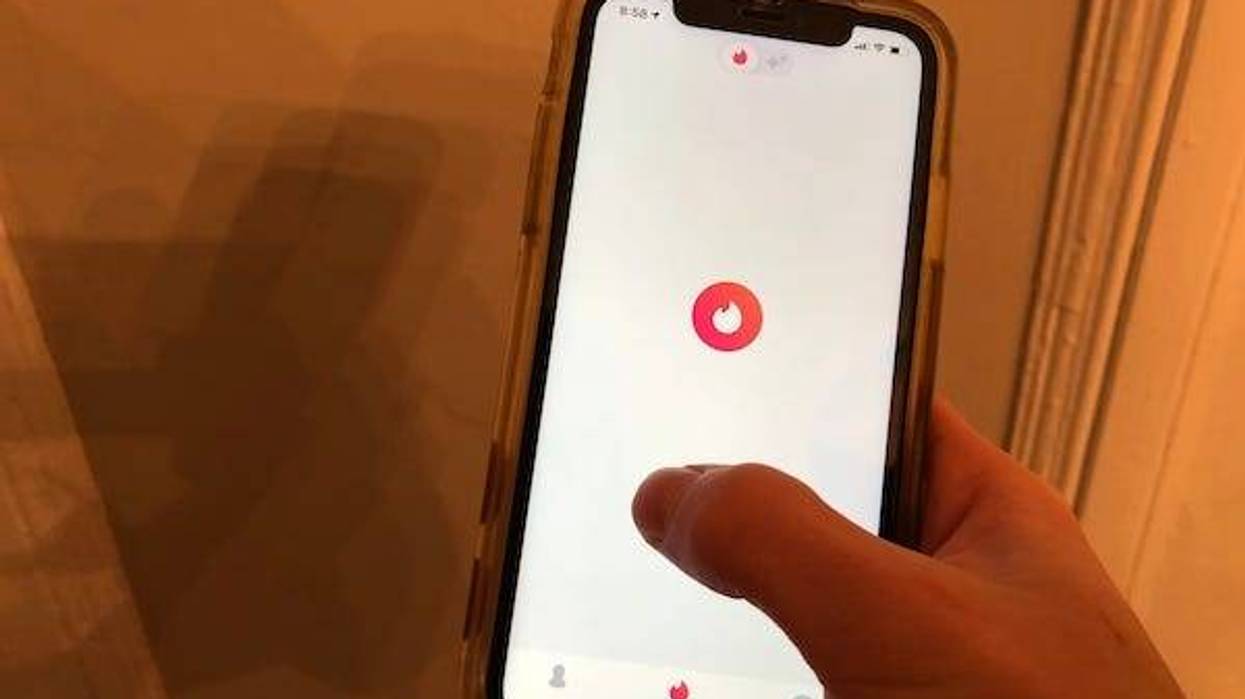 Person tapping on Tinder dating app