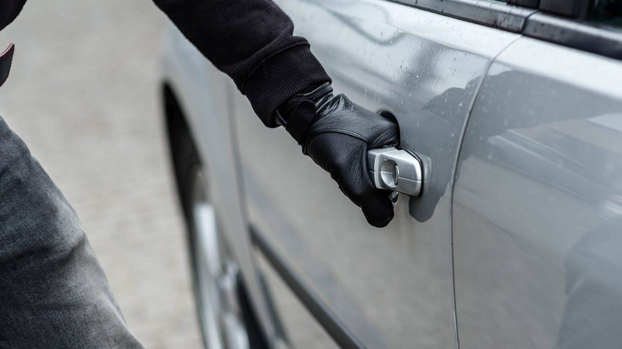 Person trying to break into a car