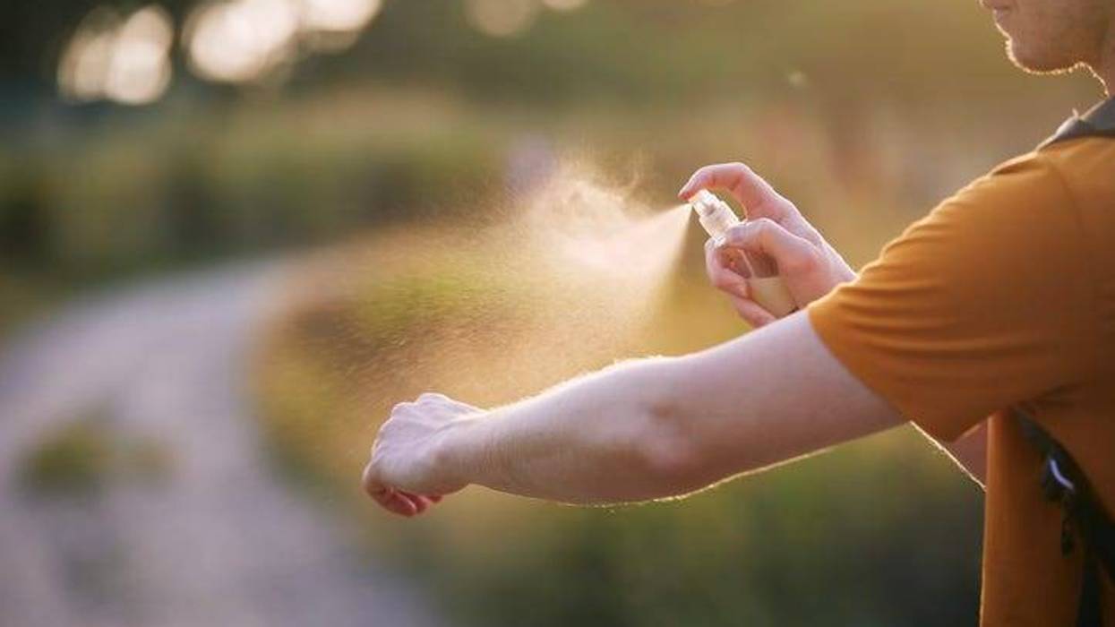 Person uses repellent to ward off mosquitoes