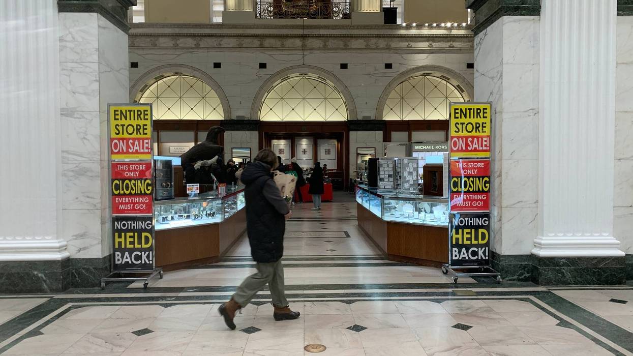 Person walking by Macy's discount signs