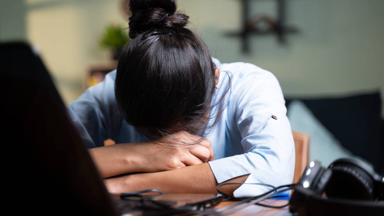Person with head down at desk