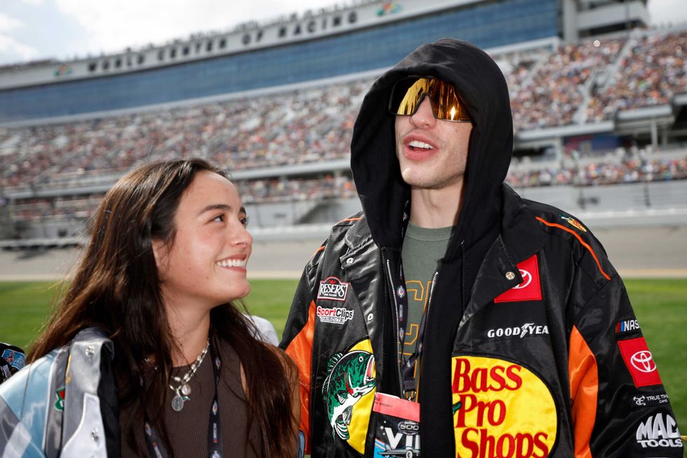 Pete Davidson and girlfriend Chase Sui talk on the grid prior to the NASCAR Cup Series 65th Annual Daytona 500 at Daytona International Speedway on February 19, 2023 in Daytona Beach, Florida.
