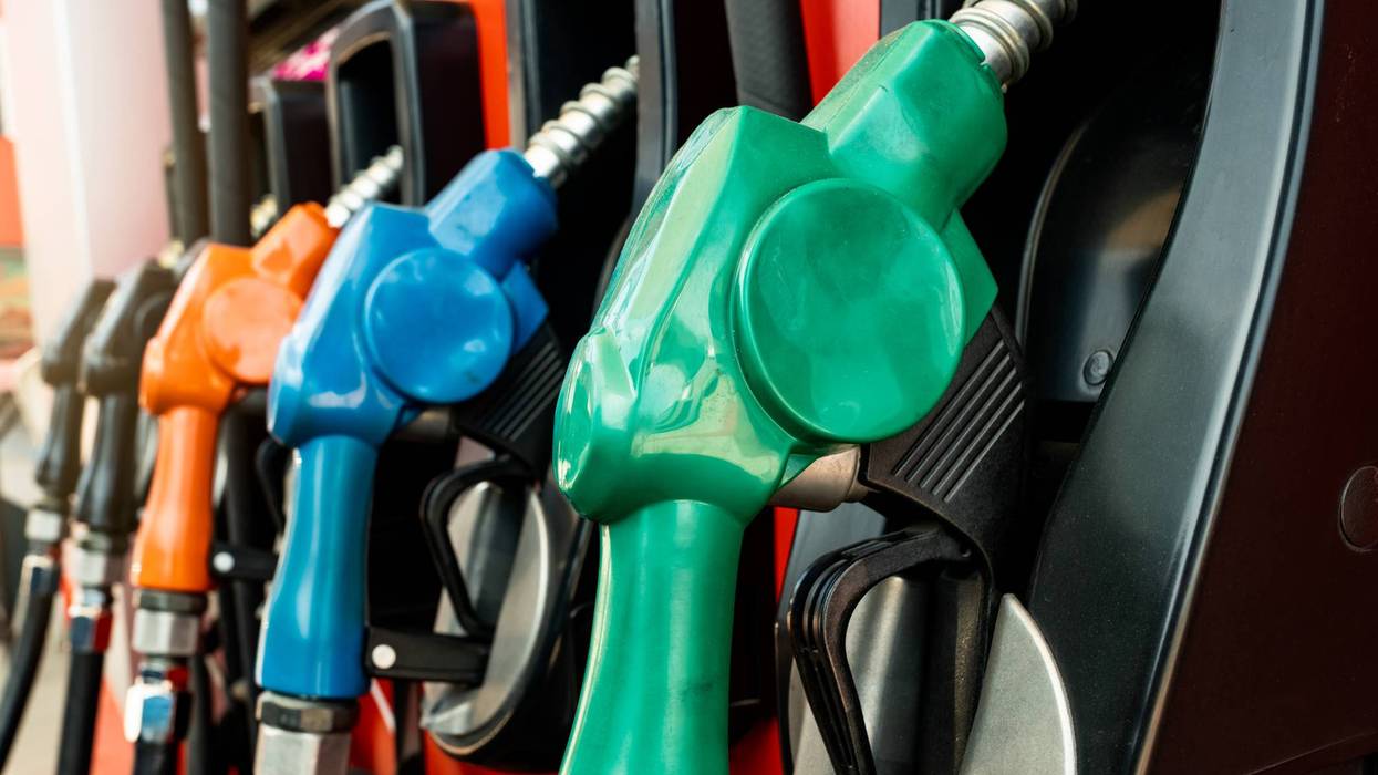 Petrol pump filling fuel nozzle in gas station. Fuel dispenser machine. Refuel fill up with petrol gasoline. Petrol industry and service. Red petrol fuel nozzle. Petroleum oil industry. Oil crisis.