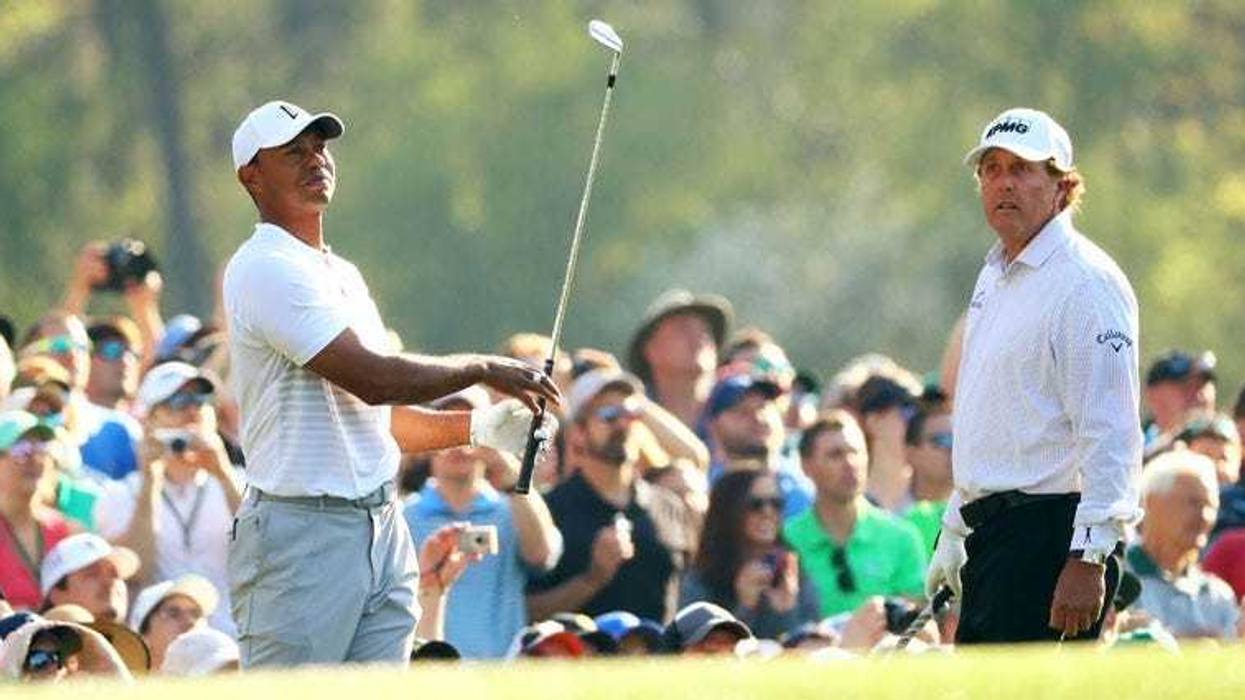 Phil Mickelson watches Tiger Woods play his tee shot on the 12th hole during a practice round for the Masters on April 3, 2018, at Augusta National.