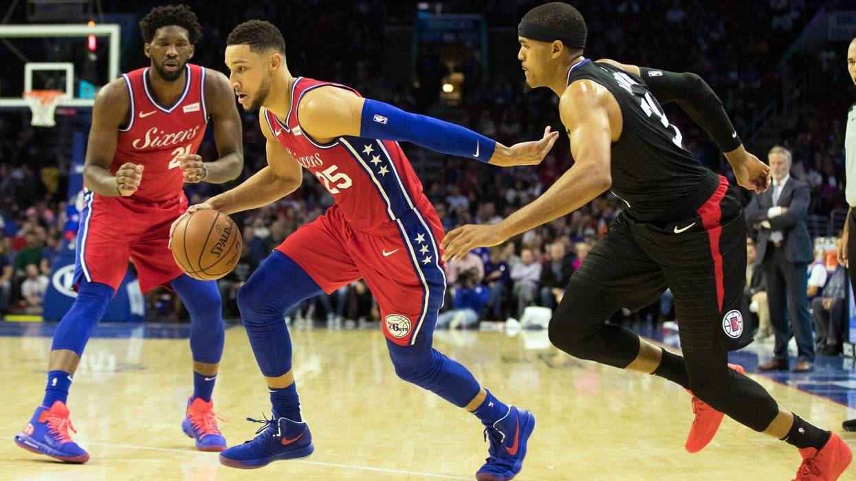 Philadelphia 76ers guard Ben Simmons dribbles past LA Clippers forward Tobias Harris in front of center Joel Embiid during the third quarter at Wells Fargo Center on Nov 1, 2018.