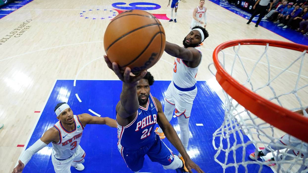 Philadelphia 76ers' Joel Embiid, center, goes up for a shot against New York Knicks' Mitchell Robinson, right, and Josh Hart during the first half of Game 3 in an NBA basketball first-round playoff series, Thursday, April 25, 2024, in Philadelphia.